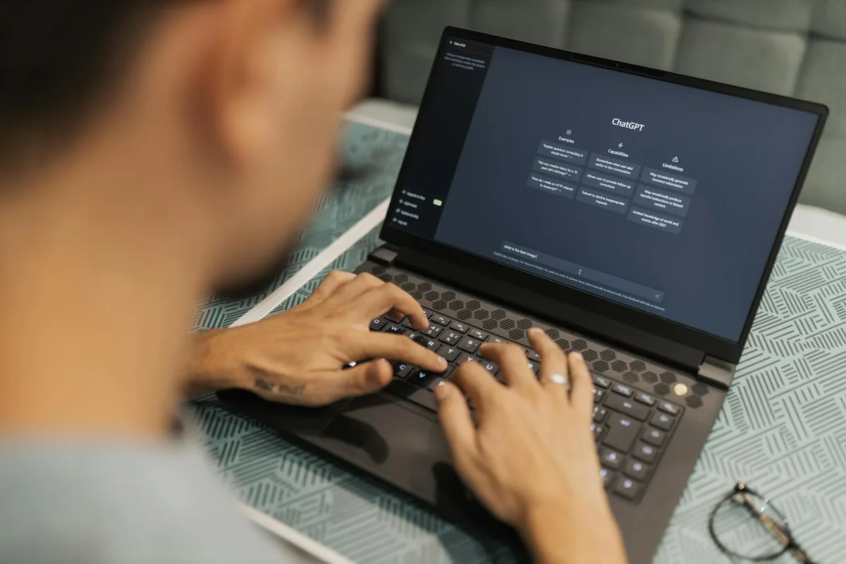 A person using ChatGPT on a laptop screen to generate lead magnet ideas and content, sitting at a clean desk workspace